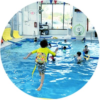 A kids jumping in a pool with children in it.