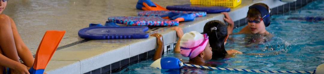 Mom kissing her toddler during a mommy and me swim class.