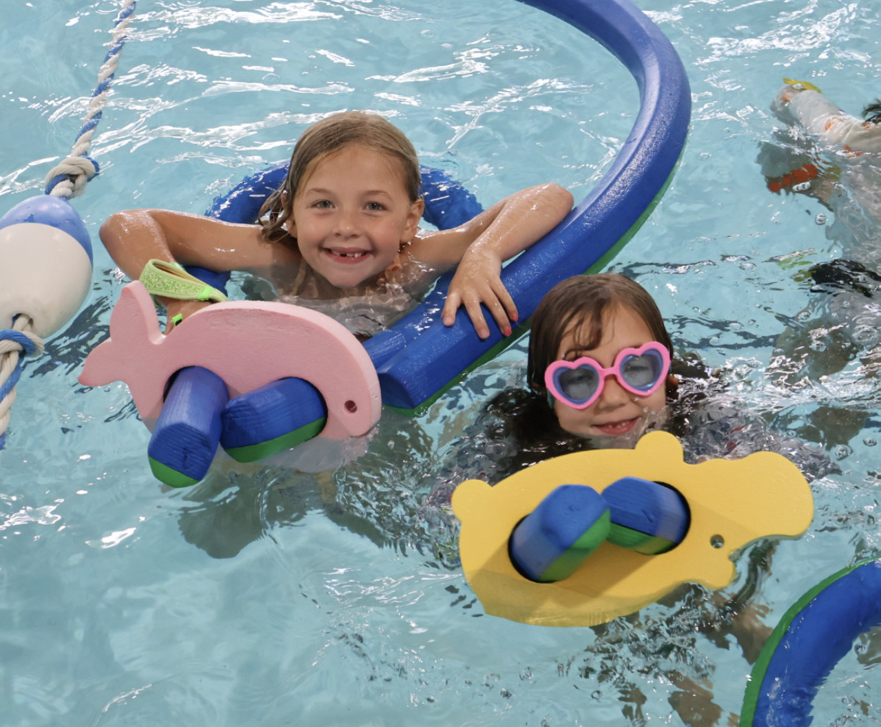 A bunch of children playing in the pool.