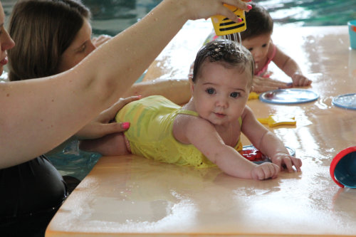 A baby taking swim lessons.